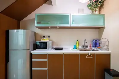 a kitchen with a refrigerator and a microwave at 2Bedrooms Maritime Luxury Seaview Suite 2-10pax in Jelutong