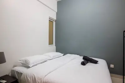 a white bed with a black object on top of it at 2Bedrooms Maritime Luxury Seaview Suite 2-10pax in Jelutong