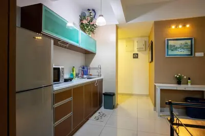 a kitchen with brown cabinets and a microwave at 2Bedrooms Maritime Luxury Seaview Suite 2-10pax in Jelutong