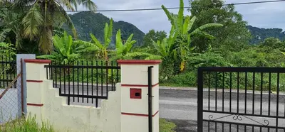 a black fence with a gate and a road at LOST WORLD OF TAMBUN HOMESTAY in Kampong Batu Lapan