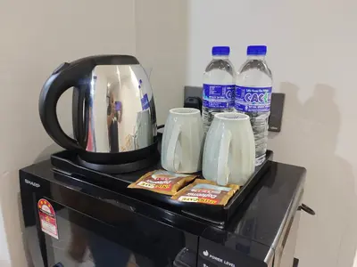 a counter with two bottles of water on top of a appliance at Alish Studio Apartment with Pool, Netflix, Wifi in Gua Musang