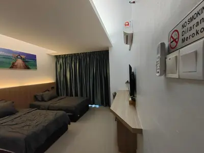 a hotel room with two beds and a television at Alish Studio Apartment with Pool, Netflix, Wifi in Gua Musang
