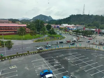 an empty parking lot with cars in a city at Alish Studio Apartment with Pool, Netflix, Wifi in Gua Musang