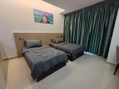 a bedroom with two beds and a window with green curtains at Alish Studio Apartment with Pool, Netflix, Wifi in Gua Musang