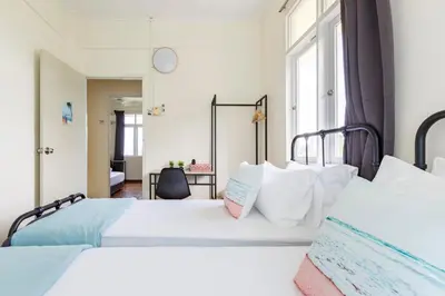 a bedroom with two beds and a window at EE's Surfer's House - Seaview, 3 min walk to beach in Batu Ferringhi