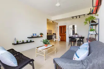a living room with a couch and a table at EE's Surfer's House - Seaview, 3 min walk to beach in Batu Ferringhi