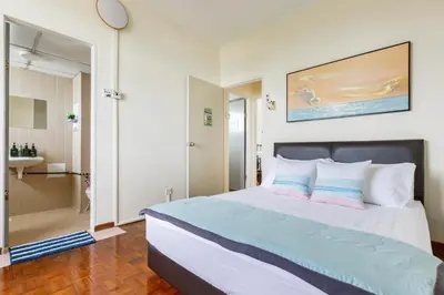 a bedroom with a large bed and a bathroom at EE's Surfer's House - Seaview, 3 min walk to beach in Batu Ferringhi