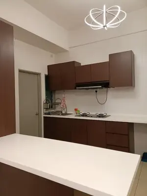 a kitchen with brown cabinets and a white counter top at Alyaleesya homestay muslim night market in Brinchang