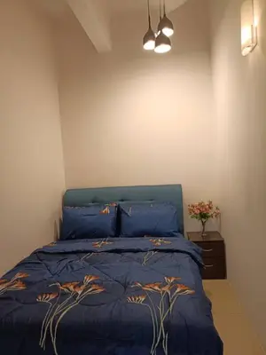 a bedroom with a blue bed with a blue comforter at Alyaleesya homestay muslim night market in Brinchang