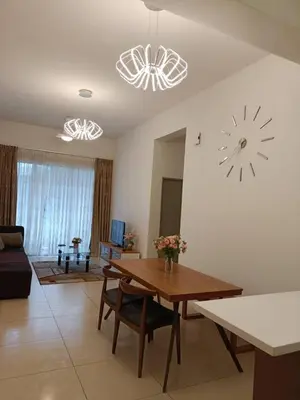 a living room with a table and a clock on the wall at Alyaleesya homestay muslim night market in Brinchang