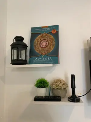 a book sitting on a shelf next to two plants at Jasmine Homestay Meru Ipoh in Ipoh
