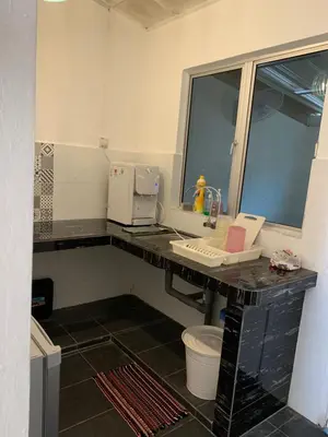 a bathroom with a counter with a sink and a window at Jasmine Homestay Meru Ipoh in Ipoh