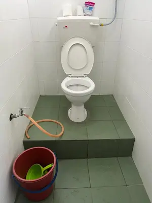 a small bathroom with a toilet and a bucket at Homestay Malim Nawar in Malim Nawar