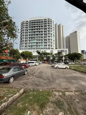 a parking lot with cars parked in front of a tall building at 6 PAX 1 BEDROOM SOHO near SPICE ARENA PANTAI SPECIALIST AIRPORT in Bayan Lepas