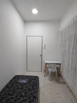 a room with a bed and a table and a door at GP Hostel Penang in George Town