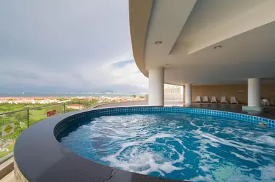 a large swimming pool with a view of the ocean at The Regency Luxury Suite -Gurney Strait Quay in Tanjong Tokong