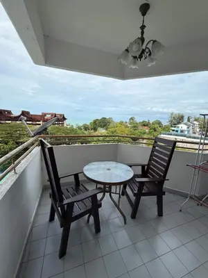 a table and two chairs on a balcony with a view at Batu Feringgi Sri Sayang Apartment in Batu Ferringhi