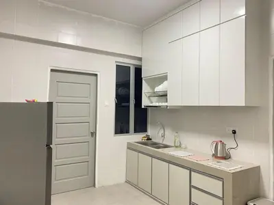 a kitchen with white cabinets and a sink at \u4f11\u95f2\u6c11\u5bbf Leisure Homestay @The Venus Sitiawan in Kampong Lumut Kiri