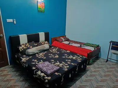 a bedroom with two beds and a blue wall at SR Kampar Homestay, Bandar Baru Kampar in Kampar