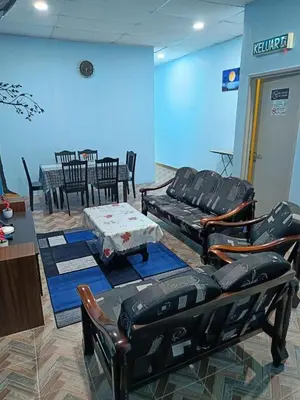 a living room with chairs and a couch and a table at SR Kampar Homestay, Bandar Baru Kampar in Kampar