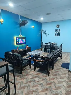 a waiting room with black chairs and a blue wall at SR Kampar Homestay, Bandar Baru Kampar in Kampar