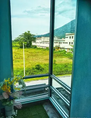 a window with a view of a field and buildings at SR Kampar Homestay, Bandar Baru Kampar in Kampar