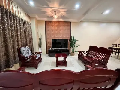 a living room with two chairs and a television at Grand Homestay Kulim 4-Bedroom in Lunas