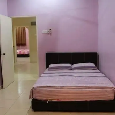 a bed in a bedroom with a pink wall at Grand Homestay Kulim 4-Bedroom in Lunas