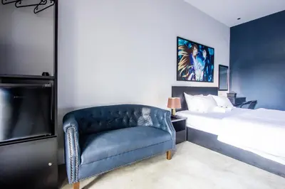 a bedroom with a bed and a blue couch at CITY HUNTER At Georgetown in George Town
