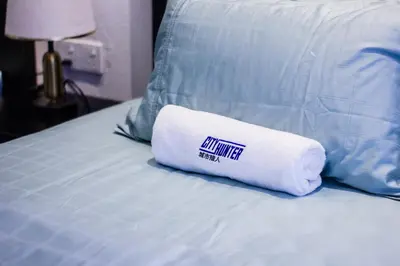 a white towel sitting on top of a bed at CITY HUNTER At Georgetown in George Town