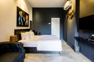 a bedroom with a bed and a couch and a television at CITY HUNTER At Georgetown in George Town