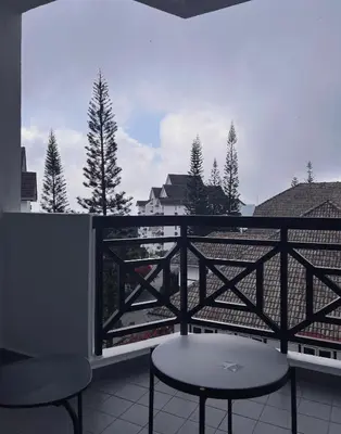 a balcony with a table and chairs on a balcony at Blossom Silverpark Apartment in Bukit Fraser