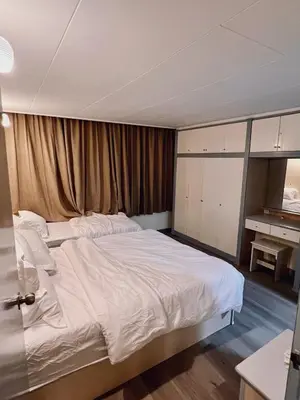 a bedroom with a large bed with white sheets at Blossom Silverpark Apartment in Bukit Fraser