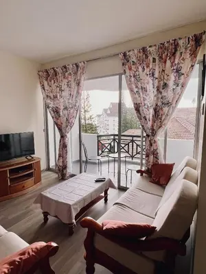 a living room with a couch and a large window at Blossom Silverpark Apartment in Bukit Fraser