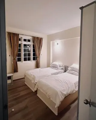 a bedroom with two beds and a window at Blossom Silverpark Apartment in Bukit Fraser