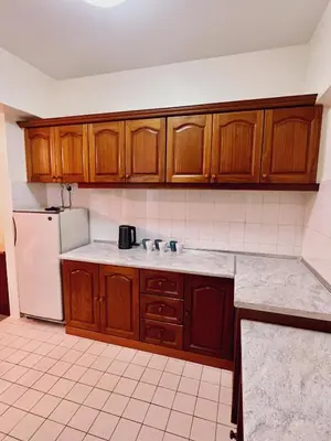 a kitchen with wooden cabinets and a white refrigerator at Blossom Silverpark Apartment in Bukit Fraser