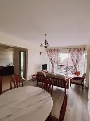 a living room with tables and chairs and a large window at Blossom Silverpark Apartment in Bukit Fraser