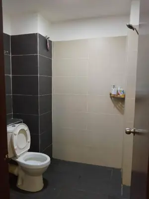 a bathroom with a toilet and a black and white wall at Armada Sweet Homestay in Gua Musang