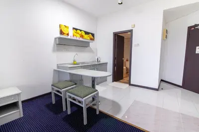 a kitchen with a table and two stools at Rainbow paradise at Tanjung Bungah in Tanjung Bungah