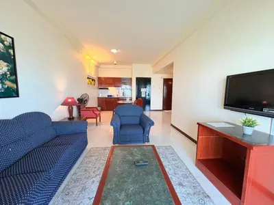 a living room with a blue couch and a flat screen tv at Rainbow paradise at Tanjung Bungah in Tanjung Bungah