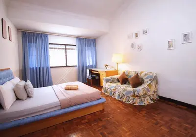 a bedroom with a bed and a chair and a desk at Advent Villa, just 80 meters to Penang Adventist Hospital in George Town