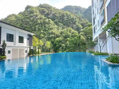 a swimming pool in front of a building with a mountain at Sunway Onsen Theme Park View @Lost World of Tambun in Ipoh