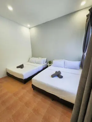 two beds in a room with white walls at Gurney Coast Guest House by Sky Hive in George Town