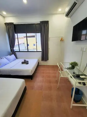 a bedroom with two beds and a table and a desk at Gurney Coast Guest House by Sky Hive in George Town