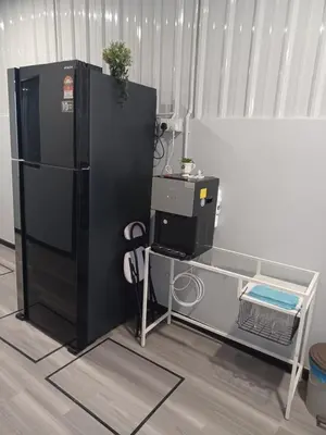 a black refrigerator next to a desk with a computer at Gurney Coast Guest House by Sky Hive in George Town