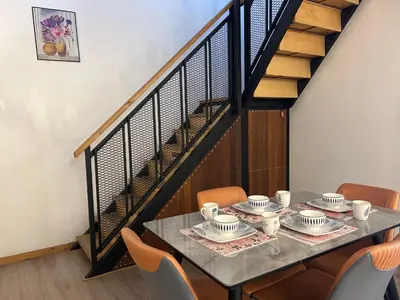 a dining room table with chairs and a staircase at Ipoh Family Homestay Masjid Muhammadiah Evicharger SY16 in Ipoh