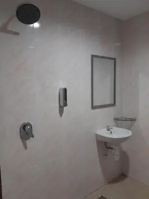 a white bathroom with a sink and a mirror at The Great Hotel in Ipoh