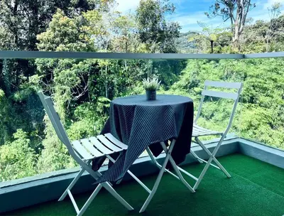 a table and two chairs sitting on a balcony at Cozystay @ The Quintet, Cameron in Tanah Rata