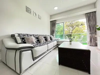 a living room with white furniture and a large window at Cozystay @ The Quintet, Cameron in Tanah Rata