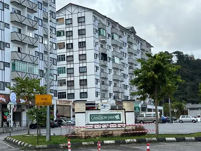 a large apartment building with a sign in front of it at Cozystay @ The Quintet, Cameron in Tanah Rata